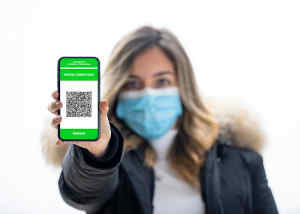 donna con smartphone e schermata con green pass